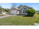 Charming single-story home featuring a well-manicured lawn, landscaping, and two car garage at 112 Thorne Meadow Pass, Davenport, FL 33897