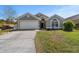 Charming single-story home featuring a well-manicured lawn and attached two car garage at 112 Thorne Meadow Pass, Davenport, FL 33897