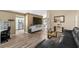 Open concept living room featuring wood floors and a large tv at 112 Thorne Meadow Pass, Davenport, FL 33897