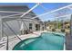 A screened-in pool and spa are connected to the home by a patio with lounge seating at 112 Thorne Meadow Pass, Davenport, FL 33897