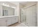 Bright bathroom featuring double sinks with white cabinets and a glass-enclosed shower at 2047 Rosewood Cir, Lakeland, FL 33810