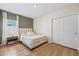 Cozy bedroom featuring a green accent wall and natural light from the window at 2047 Rosewood Cir, Lakeland, FL 33810