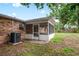 Rear exterior view of home featuring screened in lanai, lawn and brick facade at 2322 Northview Dr, Lakeland, FL 33810