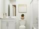 Clean and bright bathroom featuring a modern vanity, toilet, and shower with a white curtain at 1261 Deepwater Cir, Eagle Lake, FL 33839
