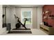 Bright home gym with exercise equipment, weight rack, storage shelves, and a red accent wall for motivation at 1261 Deepwater Cir, Eagle Lake, FL 33839