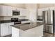 Modern kitchen featuring stainless steel appliances, white cabinets, and a center island with a sink at 1542 Sage Ave, Haines City, FL 33844