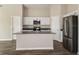 Bright kitchen features an island, stainless steel appliances, and white cabinets at 1542 Sage Ave, Haines City, FL 33844