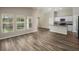 Spacious living room with hardwood floors, bright windows, and open layout leading to the kitchen at 1542 Sage Ave, Haines City, FL 33844