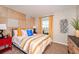 This modern bedroom features vibrant textiles, stylish furnishings, and a creative wood paneled accent wall at 1566 Sage Ave, Haines City, FL 33844