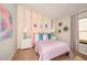 This charming bedroom offers vibrant decor, including a colorful accent wall and whimsical artwork at 1566 Sage Ave, Haines City, FL 33844