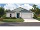 Charming single-story home with manicured lawn, attached two-car garage, and modern architectural details at 1570 Sage Ave, Haines City, FL 33844