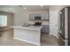 Open kitchen with island, stainless appliances, and wood-look floors; bright, modern design at 1570 Sage Ave, Haines City, FL 33844