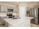 Modern kitchen featuring stainless steel appliances, center island, and sleek gray cabinetry at 1570 Sage Ave, Haines City, FL 33844