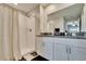 Clean bathroom featuring a walk-in shower, white cabinets, granite countertops, and a large mirror at 1792 Yellow Trl, Lakeland, FL 33801