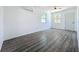 Bedroom with gray wood-look floors, white walls, AC unit, ceiling fan, and windows for natural light at 218 W Magnolia St, Clermont, FL 34711