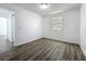 A simple bedroom offers wood-look flooring and natural light from a window at 218 W Magnolia St, Clermont, FL 34711