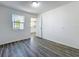 A bright bedroom features wood-look floors, white walls, and natural light from a window at 218 W Magnolia St, Clermont, FL 34711