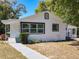 Exterior view of a charming white home with well-maintained landscaping at 218 W Magnolia St, Clermont, FL 34711