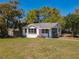 Charming single-story home with well-maintained lawn, lush landscaping, and black-trimmed windows, set beneath a clear blue sky at 218 W Magnolia St, Clermont, FL 34711