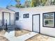 Exterior view of a white home featuring black trim and a well-maintained lawn at 218 W Magnolia St, Clermont, FL 34711