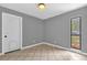 Bedroom featuring tile floors, a side window, gray walls, and white trim at 31632 Spruce Dr, Eustis, FL 32736