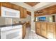 Well-lit kitchen with wood cabinets, tile floors and a view of the dining area at 31632 Spruce Dr, Eustis, FL 32736