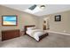Comfortable main bedroom featuring a skylight, ensuite bathroom, beach themed artwork, and cozy carpet flooring at 31632 Spruce Dr, Eustis, FL 32736