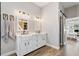 Stylish bathroom featuring a modern dual sink vanity, providing ample space and functionality, with barn door to the closet at 32421 Wolfs Trl, Sorrento, FL 32776