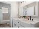 Modern bathroom features dual vanity with framed mirrors, decorative lighting and a tub with a shower at 32421 Wolfs Trl, Sorrento, FL 32776