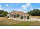 Inviting front exterior showcases a charming facade with manicured landscaping, stone accents, and a welcoming walkway at 32421 Wolfs Trl, Sorrento, FL 32776