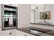 Modern kitchen with stainless steel double oven and cooktop with granite countertops and decorative wreath at 32421 Wolfs Trl, Sorrento, FL 32776