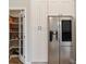 Modern kitchen featuring white cabinetry, stainless steel refrigerator and a fully stocked pantry with a glass door at 32421 Wolfs Trl, Sorrento, FL 32776