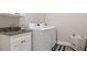 Well-lit laundry room featuring a laundry sink with granite countertops and modern washer and dryer at 32421 Wolfs Trl, Sorrento, FL 32776