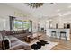 Open living space with wood floors, gray sofa, and abundant natural light at 32421 Wolfs Trl, Sorrento, FL 32776