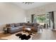 Spacious living room with wood-look tile, comfortable seating, and backyard views at 32421 Wolfs Trl, Sorrento, FL 32776