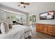 Bedroom boasts a bed, TV, and a large window view, blending comfort and convenience at 32421 Wolfs Trl, Sorrento, FL 32776