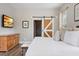 Cozy bedroom features wood floors, barn door to bath, TV, and dresser, providing an inviting retreat at 32421 Wolfs Trl, Sorrento, FL 32776