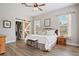 Spacious bedroom with wood-look flooring, barn doors, and a king bed set for ultimate comfort and style at 32421 Wolfs Trl, Sorrento, FL 32776