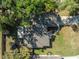 Aerial view of a house with lush trees, long drive way, and other structures at 5416 Oxford Manor Cir, Lakeland, FL 33810