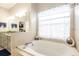 Bright bathroom features a soaking tub, tiled surround, and double vanity sinks at 5416 Oxford Manor Cir, Lakeland, FL 33810