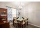 Elegant dining area with a modern chandelier, a glass-topped table, and decorative patterned curtains at 5416 Oxford Manor Cir, Lakeland, FL 33810