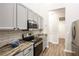 Modern kitchen featuring stainless steel appliances, light grey cabinetry, and wood-look floors at 5416 Oxford Manor Cir, Lakeland, FL 33810