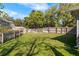 A large, fenced backyard features lush green grass, mature trees, and a storage shed at 638 Coral Way, Winter Springs, FL 32708
