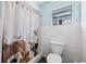 Bathroom featuring white tile, a patterned shower curtain, and a window bringing in natural light at 4305 Hamilton Rd, Lakeland, FL 33811