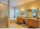 Bathroom featuring a double sink vanity, soaking tub, and walk-in shower at 8427 Prestbury Dr, Orlando, FL 32832