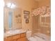 Bathroom featuring a single sink vanity and shower/tub combo with a floral curtain at 8427 Prestbury Dr, Orlando, FL 32832