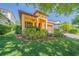 Beautiful home featuring a red front door, tan exterior, mature landscaping, and a tile roof at 8427 Prestbury Dr, Orlando, FL 32832