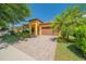 Inviting home featuring a well-maintained lawn, paver driveway, and a two-car garage at 8427 Prestbury Dr, Orlando, FL 32832