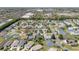 A neighborhood aerial view shows well-spaced homes with groomed landscaping and community amenities in a suburban setting at 604 Ellsworth Way, The Villages, FL 32162