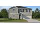 Two-story home featuring a two-car garage, neutral paint, lawn, and shrubbery at 1157 Hour Glass Rd, Lakeland, FL 33801